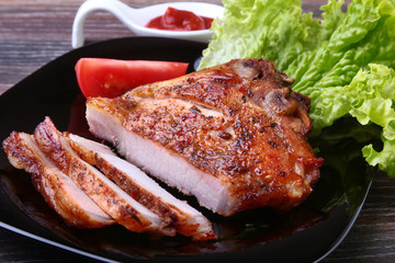 grilled pork chops with tomato, leaves lettuce and ketchup on plate.