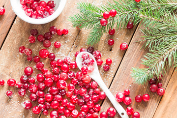 Cranberry with sugar scattered on a wooden table