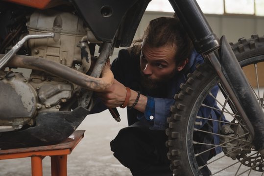 Mechanic repairing motorcycle