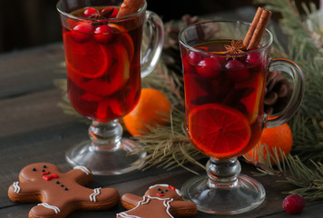Mulled wine. Christmas hot drink with citrus, apple and spices in a glass cup and gingerbread...