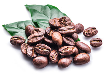 Roasted coffee beans and leaves on white background.