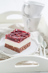 Sweet jelly cherry cake on white plate with cream