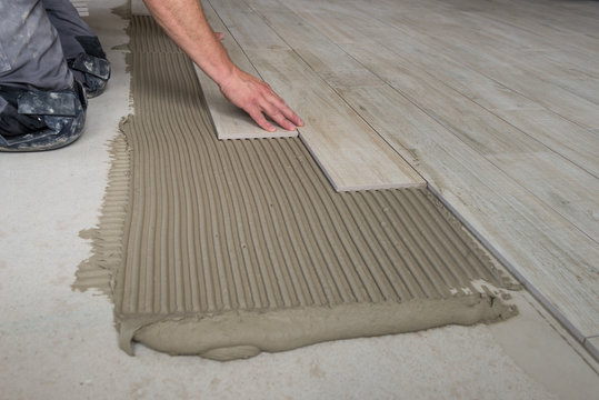 Keramische Platten werden am Boden verlegt.