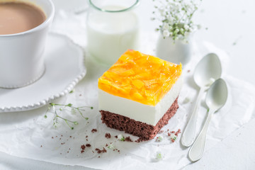 Fresh cake with jelly and peaches served with coffee