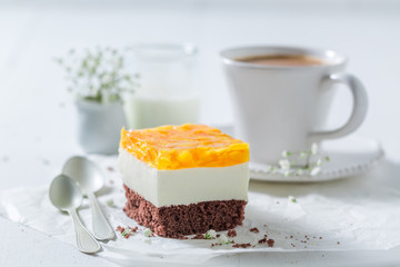 Sweet cake with jelly and peaches served with coffee