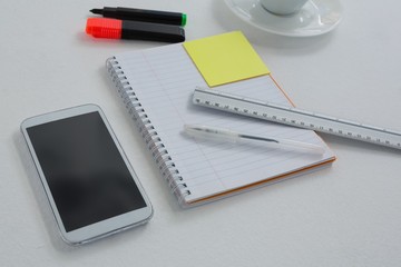 Mobile phone and stationery on white background