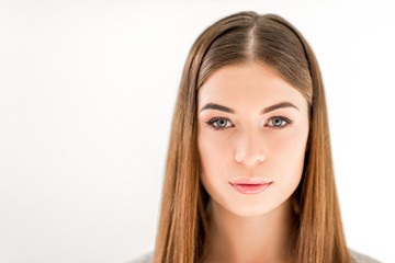 headshot of beautiful young woman with straight hair looking at camera isolated on white