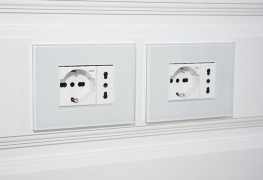Modern outlet plug on the white wall for TV. Socket and European Power in the New Flat.