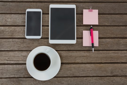 Black coffee, mobile phone, digital tablet, pen and sticky note