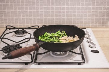 Green beans with chicken stewed on a cast-iron frying pan