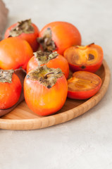 Plate of fresh and ripe persimmons. Close up.