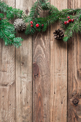 
A wooden background with sprigs of fir cones and cranberries. Christmas background. - 183930980