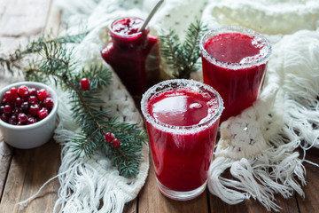 Cranberry juice in glasses on a wooden background with spruce branches. - 183931101