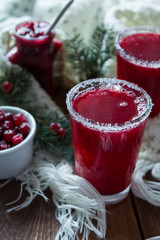 Cranberry juice in glasses on a wooden background with spruce branches. - 183931128