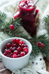Cranberry with sugar in a white plate and cranberry jam in a jar - 183931159