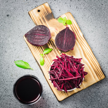 Grated beetroot in a bowl, beetrot juice on stone background. Top view, copy space.