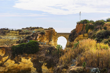 background landscape view of an arched bridge between rocks on one of the beaches of Lagos, Albufeira, Portugal