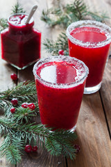 Cranberry juice in glasses on a wooden background with spruce branches. - 183933500