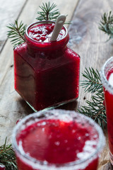 Cranberry jam in a jar on a wooden background with spruce branches. - 183933508