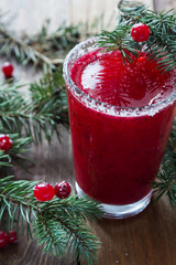 Cranberry juice in glasses on a wooden background with spruce branches. - 183933549