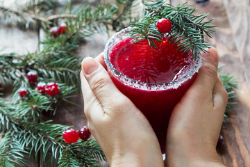 A glass of cranberry mors in the hands - 183933562