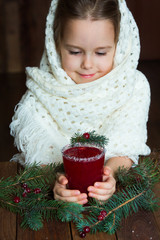 .A girl in a white knitted scarf holds a cup of cranberry mors - 183933732