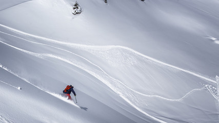 Freeride skier charging through powder snow