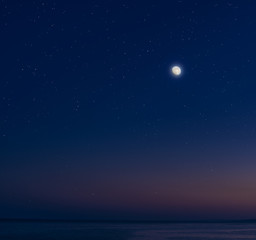 Fototapeta na wymiar Moon and stars over the calm sea.