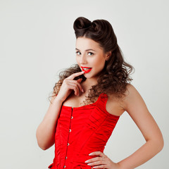 Charming lady in red corset, pin-up hairstyle