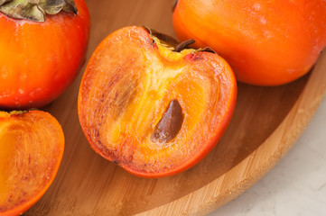 Plate of fresh and ripe persimmons. Close up.