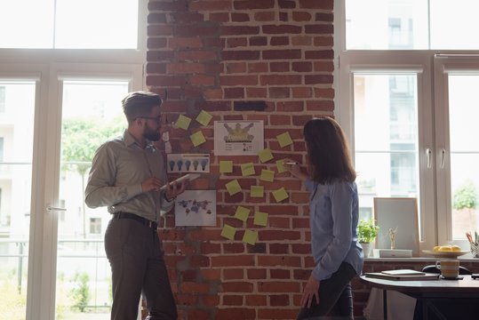 Executives discussing over sticky notes