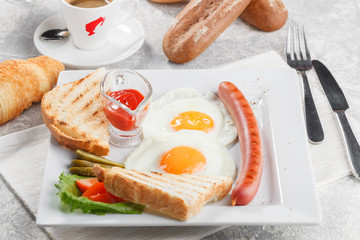 Fried eggs with toasts, sausage, vegetables and coffee with croissant. Breakfast conception