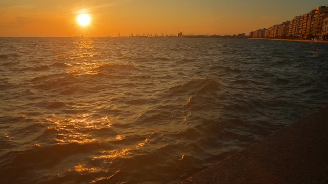Spectacular slow motion inspirational shot of the sea shore of Thessaloniki, Greece during golden hour sunset. Thessaloniki is the second major industrial, commercial and political center of Greece