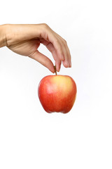 Frauenhand hält einen Apfel am Stiel