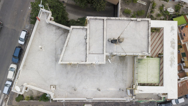 Vista aerea perpendicolare del tetto di un palazzo. Sopra di esso si trova un terrazzo calpestabile dove sono state installate le antenne e le parabole satellitari.