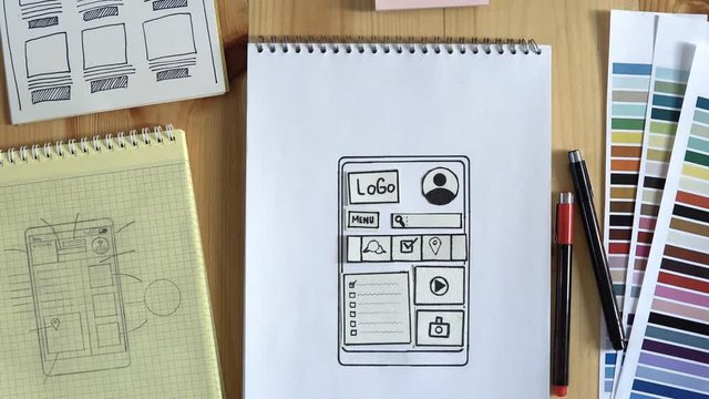 The web developer makes the layout of the website on his notebook. Filmed in stop motion.