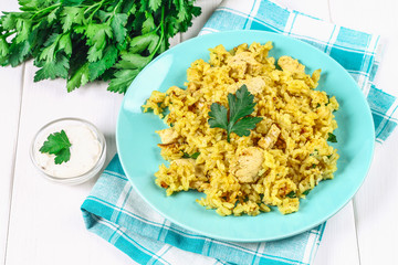 Indian biryani with chicken, yogurt and spices in a plate on a wooden table. New Year's, Christmas dish.