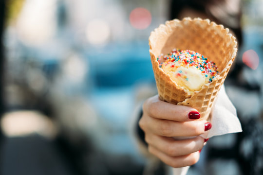 Woman holding an ice-cream with sprinkles