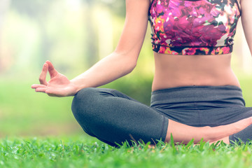 Naklejka na ściany i meble Yoga woman In the lotus posture in a park. Zen Attitude for meditation