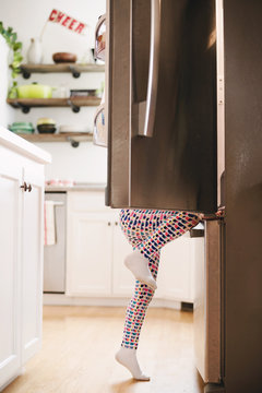 Young girl climbing into a refrigerator