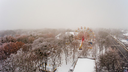 Ferris wheel in the central park of the city in winter. Aerial view.