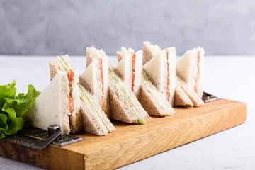 Foto op Canvas English tea sandwiches platter on wooden board © istetiana