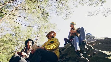 Group of friends sitting on rocks in mountains