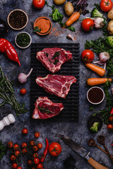 top view of raw meat slices and vegetables on black concrete surface