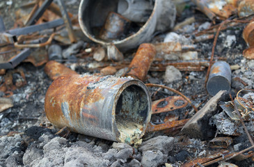 Corroded and rusty metallic components - can, and tin.  Ash, dust and dirt around destructed and...
