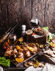Fototapeta premium delicious grilled meat with vegetables and beer on wooden background
