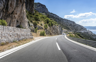 Asphalt road to the sea. Asphalt highway in a sunny day.
