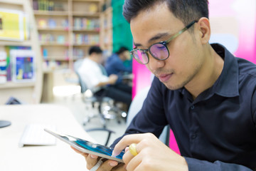 Business asian man using tablet in library