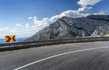 Naklejka premium Asphalt road to the sea. Asphalt highway in a sunny day.