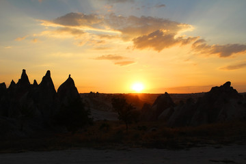 Natural valley with volcanic tuff stone rocks in Goreme in Cappadocia, Turkey, at sunset.